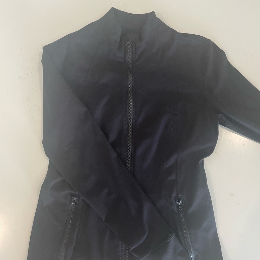 black athletic zip up 90 degree jacket with thumb holes and pockets